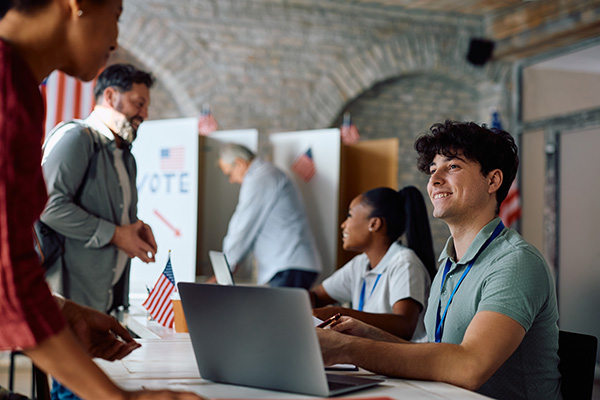 young man and woman assisting voters at a poling site